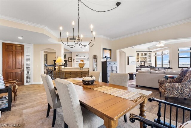 dining room with ornamental molding and light hardwood / wood-style floors