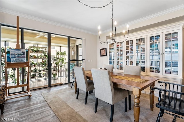 dining room with ornamental molding, hardwood / wood-style floors, and a chandelier