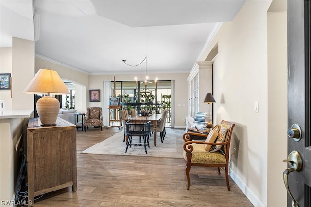 dining room featuring hardwood / wood-style floors, crown molding, a wealth of natural light, and a chandelier