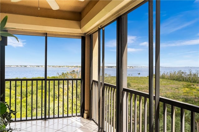 unfurnished sunroom with a water view and ceiling fan