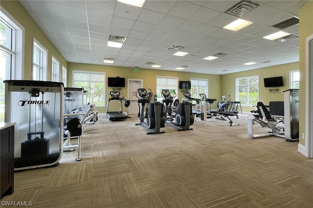 exercise room with light carpet and a drop ceiling