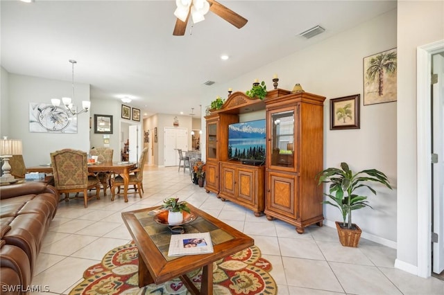 tiled living room featuring ceiling fan with notable chandelier