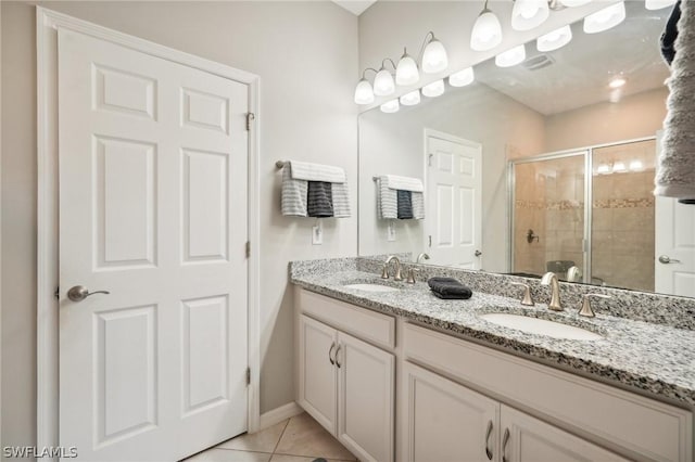 bathroom featuring tile patterned flooring, vanity, and a shower with door