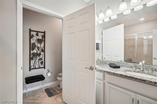 bathroom featuring tile patterned flooring, vanity, toilet, and a shower with shower door