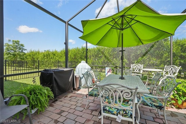 view of patio with glass enclosure and grilling area