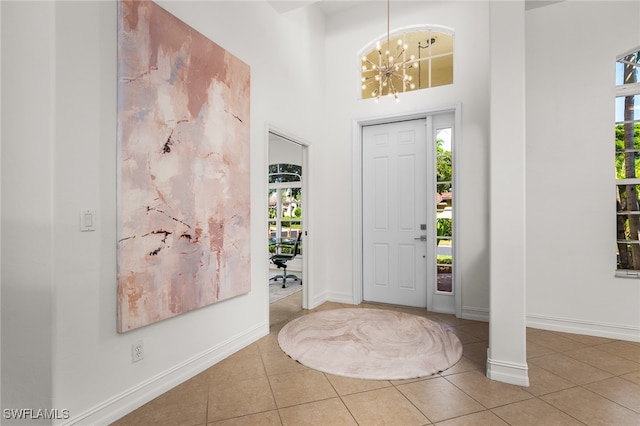 foyer featuring a high ceiling, tile patterned flooring, and a chandelier