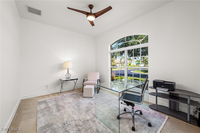 carpeted office space with ceiling fan