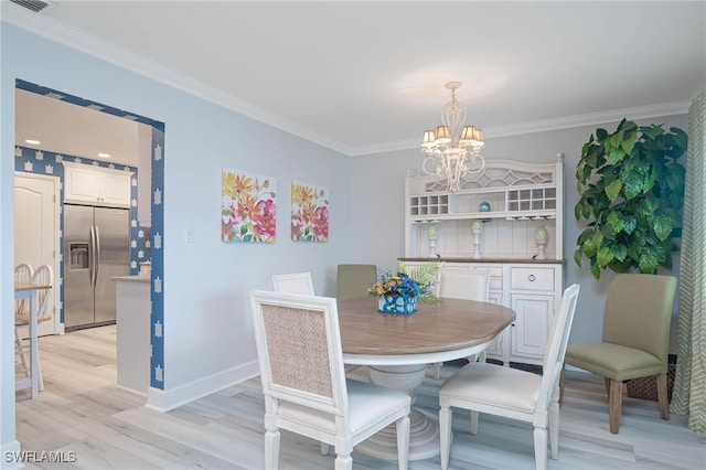 dining room with light hardwood / wood-style flooring, ornamental molding, and a chandelier