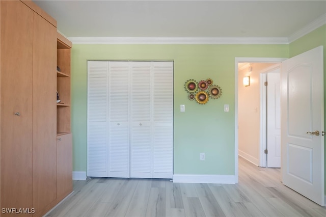 unfurnished bedroom featuring ornamental molding, light hardwood / wood-style flooring, and a closet