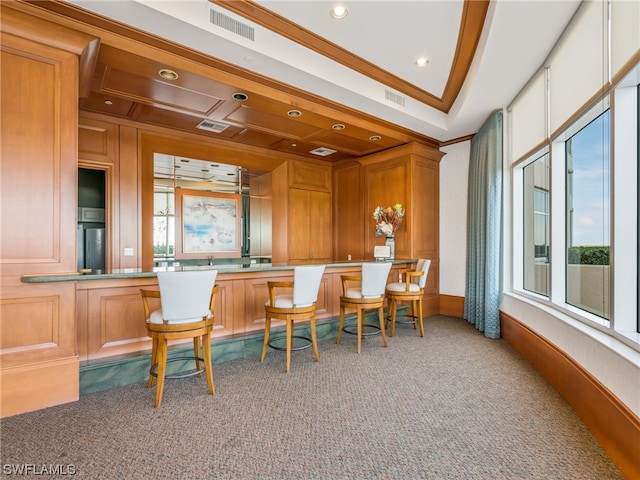 carpeted home office with ornamental molding and wooden walls