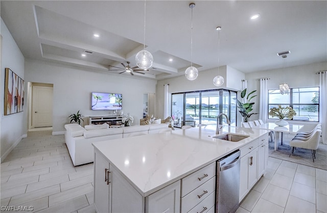 kitchen featuring a wealth of natural light, a kitchen island with sink, white cabinetry, and sink