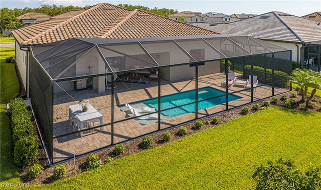 view of swimming pool featuring a lanai, a yard, and a patio