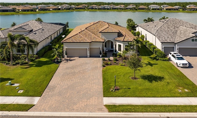 view of front facade with a water view, a front lawn, and a garage