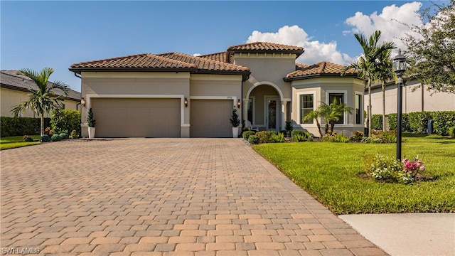 mediterranean / spanish home featuring a front lawn and a garage