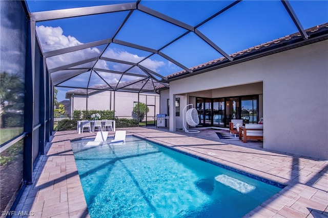 view of swimming pool featuring a patio area and glass enclosure