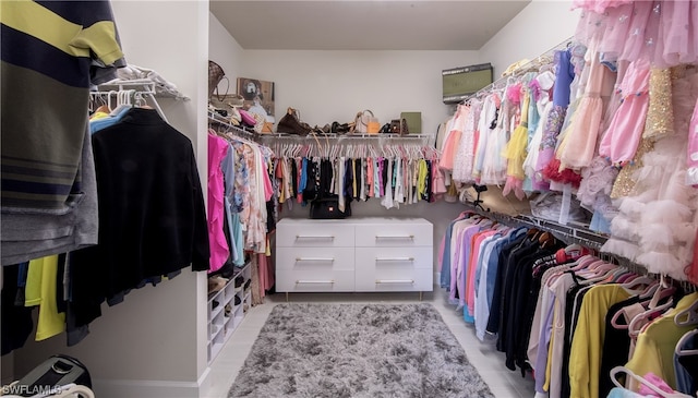 walk in closet with light tile floors