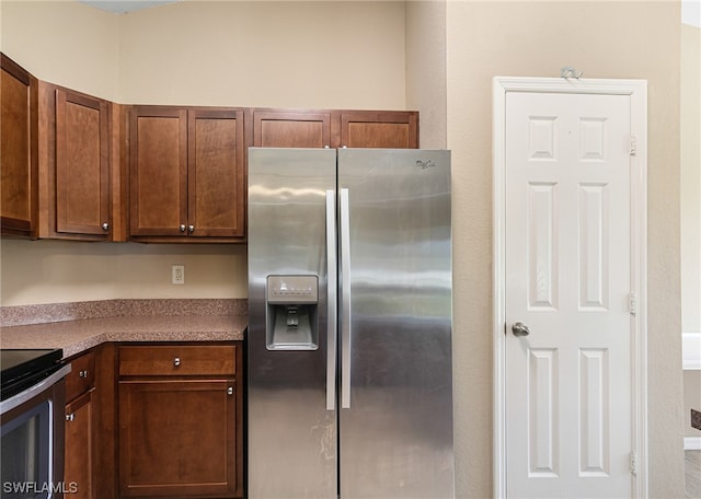 kitchen with stainless steel fridge and black range with electric stovetop