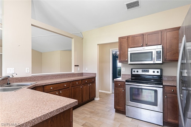 kitchen featuring light wood-type flooring, sink, and appliances with stainless steel finishes