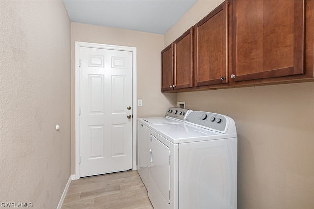 laundry room featuring light hardwood / wood-style floors, cabinets, and independent washer and dryer