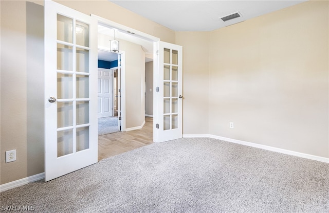 empty room with carpet flooring and french doors