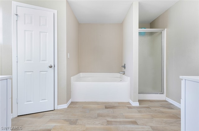 bathroom with wood-type flooring and independent shower and bath