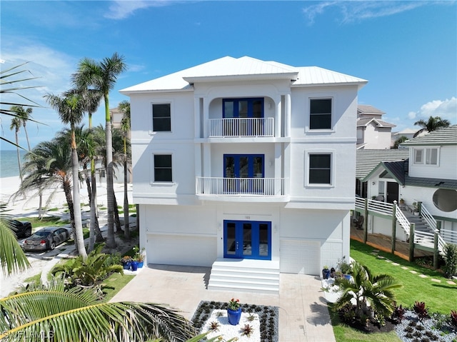 exterior space featuring a balcony, a front yard, and a garage