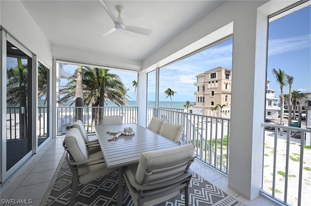 sunroom / solarium featuring a water view and ceiling fan