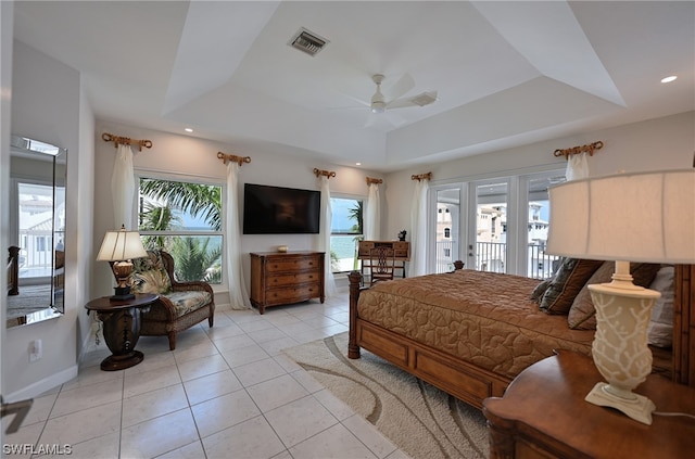 bedroom with light tile floors, access to exterior, a raised ceiling, and ceiling fan