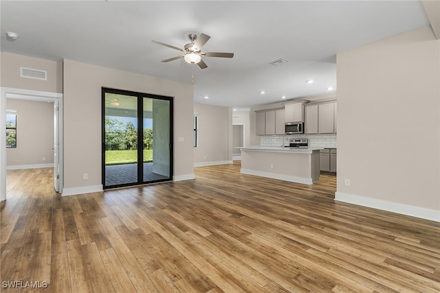 unfurnished living room with ceiling fan, plenty of natural light, and light hardwood / wood-style flooring