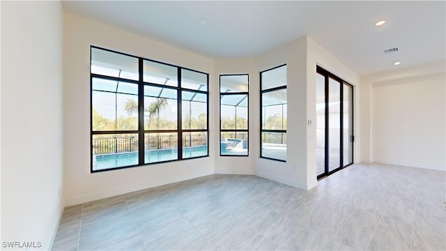 spare room featuring plenty of natural light and light tile patterned floors