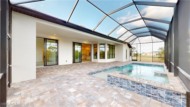 view of pool with a patio area, a lanai, and an in ground hot tub