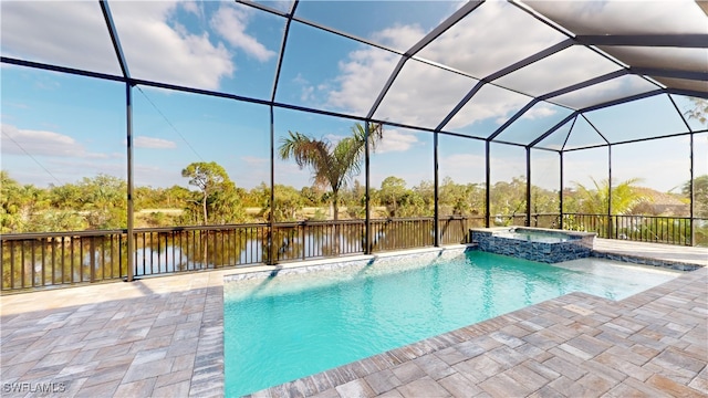 view of pool with glass enclosure, a water view, an in ground hot tub, and a patio