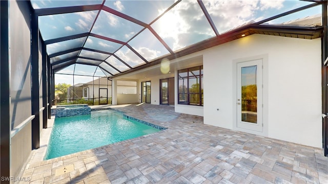 view of swimming pool with glass enclosure, a patio area, and an in ground hot tub