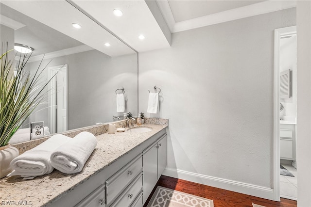 bathroom featuring crown molding, hardwood / wood-style floors, and vanity