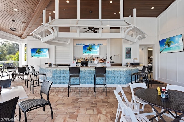 dining space featuring a high ceiling, ceiling fan, and wood ceiling