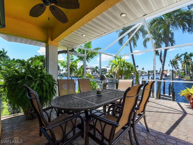 view of patio / terrace with a water view, a lanai, grilling area, and ceiling fan