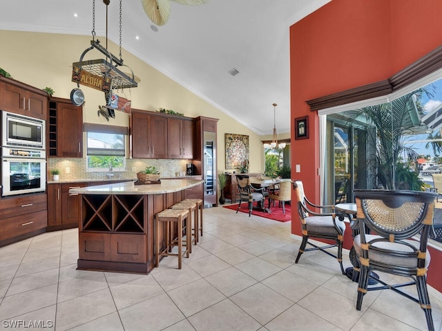 kitchen featuring pendant lighting, tasteful backsplash, appliances with stainless steel finishes, and a center island