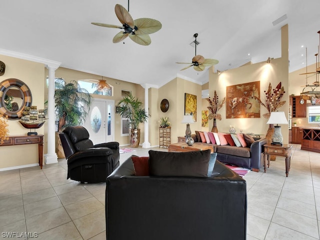 tiled living room with ornamental molding, decorative columns, ceiling fan, and a wealth of natural light
