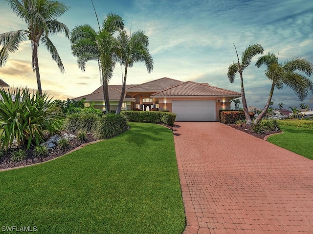 view of front of property with a garage and a yard