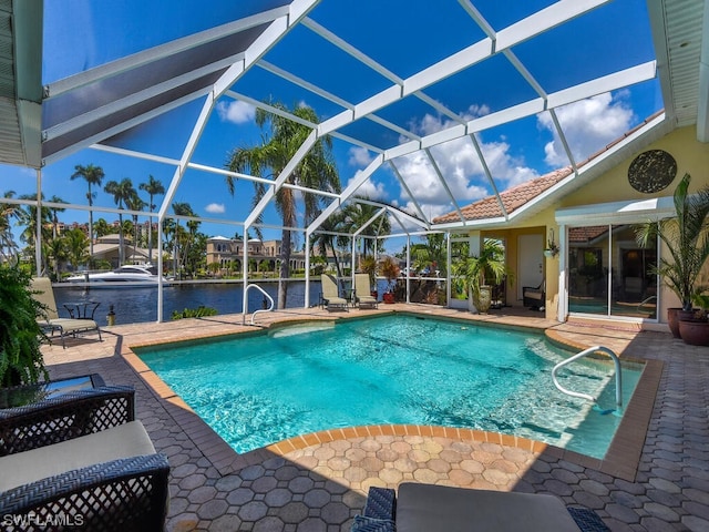 view of pool with a patio area, a water view, and a lanai