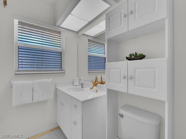 bathroom with oversized vanity, tile flooring, a wealth of natural light, and toilet