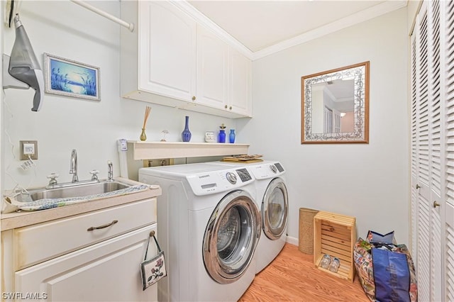 laundry area with independent washer and dryer, cabinets, crown molding, light hardwood / wood-style flooring, and sink