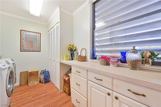 laundry area featuring light hardwood / wood-style floors, cabinets, crown molding, and washing machine and clothes dryer