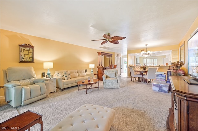 living room with carpet and ceiling fan with notable chandelier