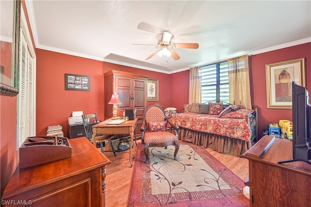 bedroom featuring ceiling fan, a closet, crown molding, and light hardwood / wood-style floors