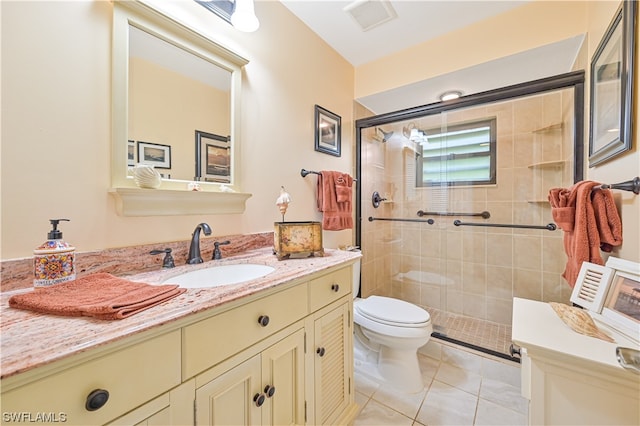 bathroom featuring walk in shower, vanity, tile patterned flooring, and toilet