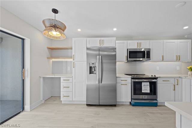 kitchen featuring hanging light fixtures, stainless steel appliances, white cabinets, and light hardwood / wood-style flooring