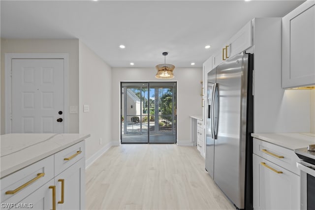 kitchen with light stone countertops, light hardwood / wood-style flooring, white cabinetry, hanging light fixtures, and stainless steel refrigerator with ice dispenser