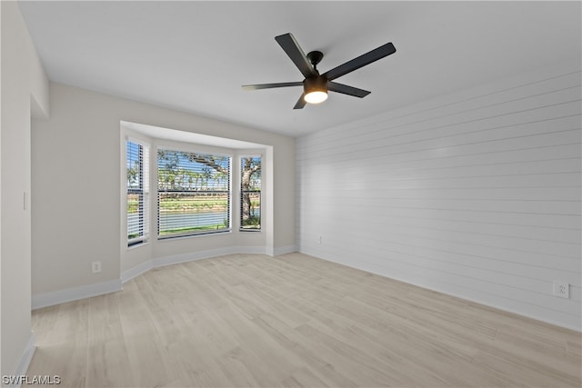 spare room with ceiling fan and light wood-type flooring