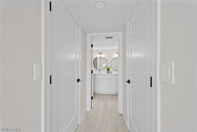 corridor with light hardwood / wood-style floors